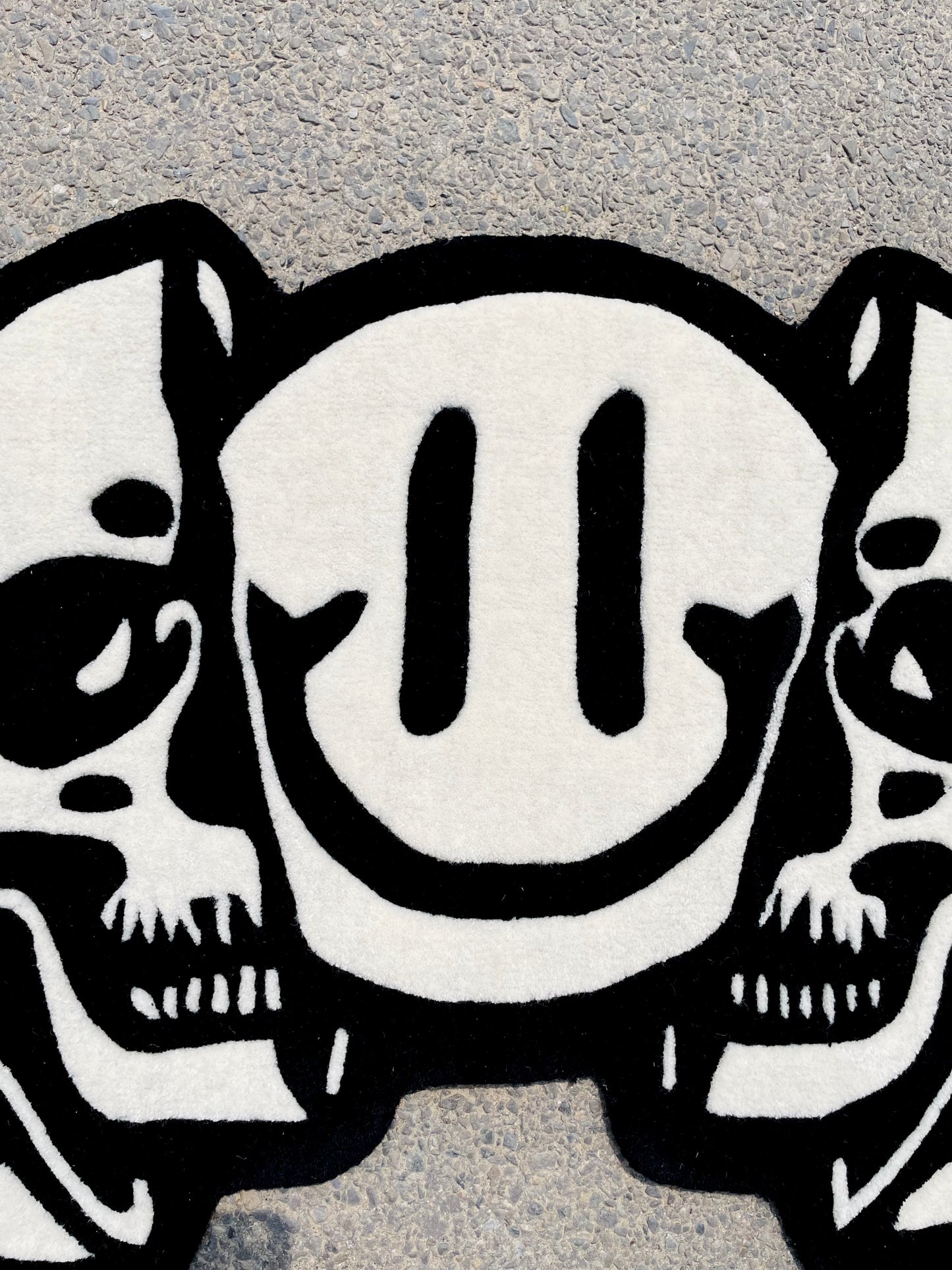 Top view of the smiley part of the monochrome triple head tufted rug displaying crisp finish and premium wool