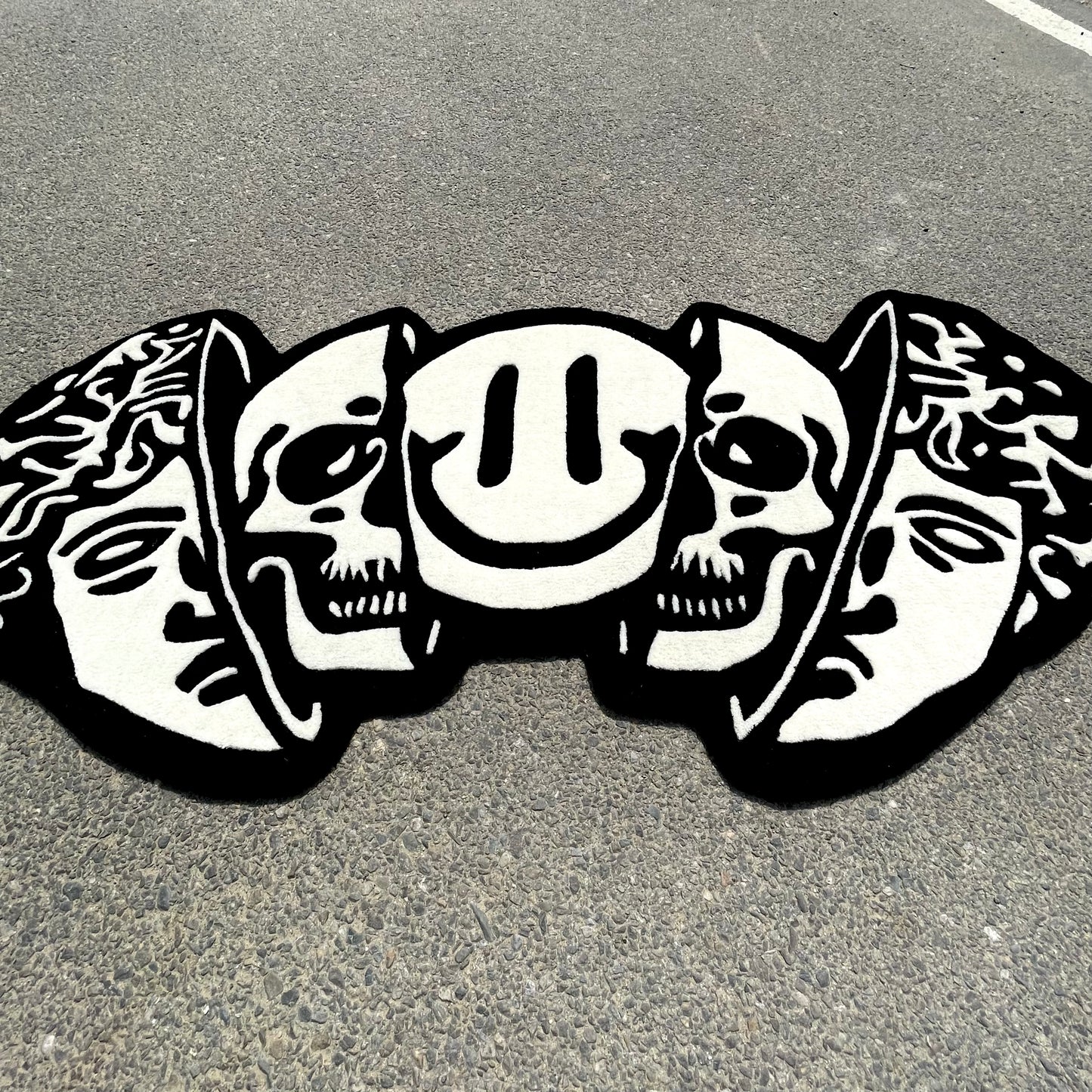 Contemporary hand-tufted rug showcasing artistic arrangement of classical greek head, skull, and smiley