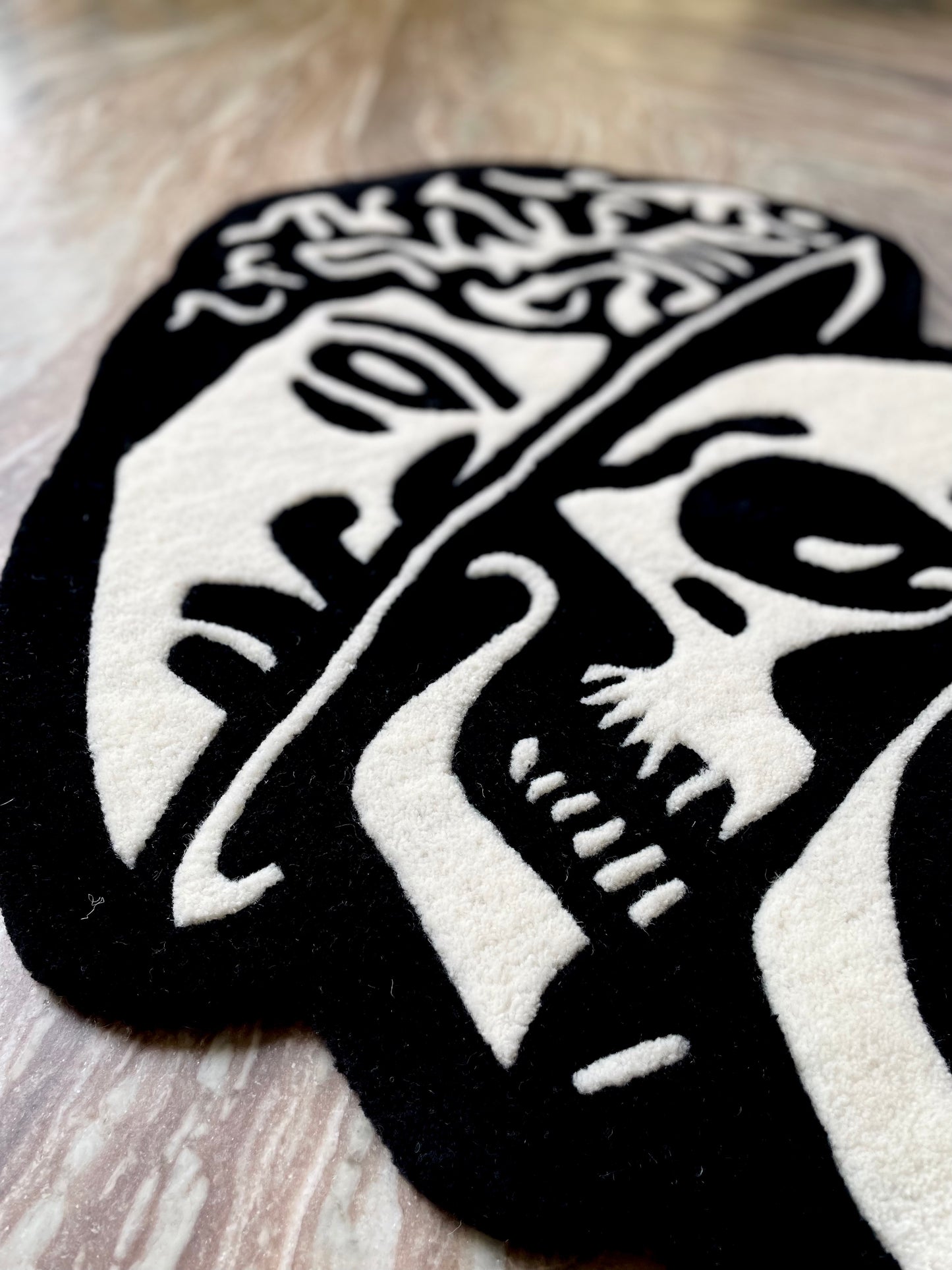 closeup of the hand-tufted rug showcasing artistic arrangement of classical head and the skull