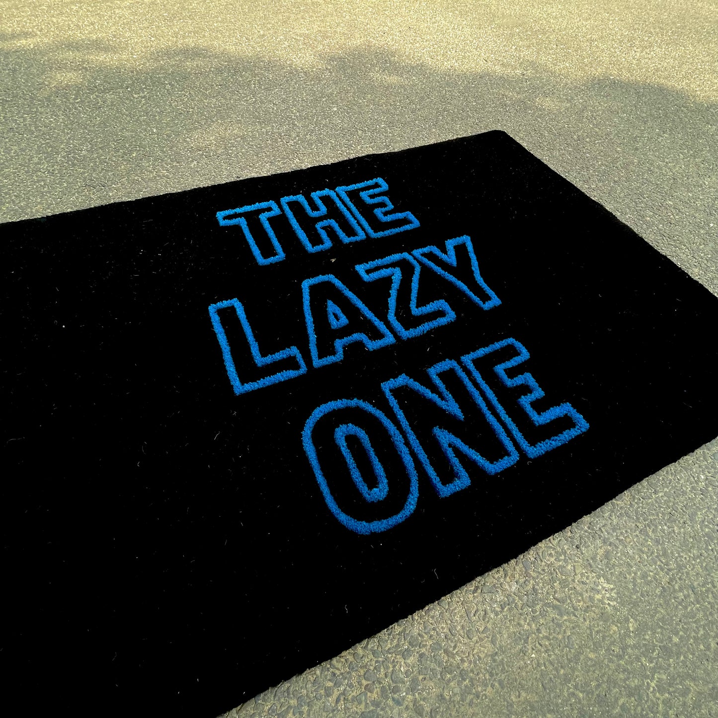 side view of our typography the lazy one custom hand tufted rug made in black and blue colourway
