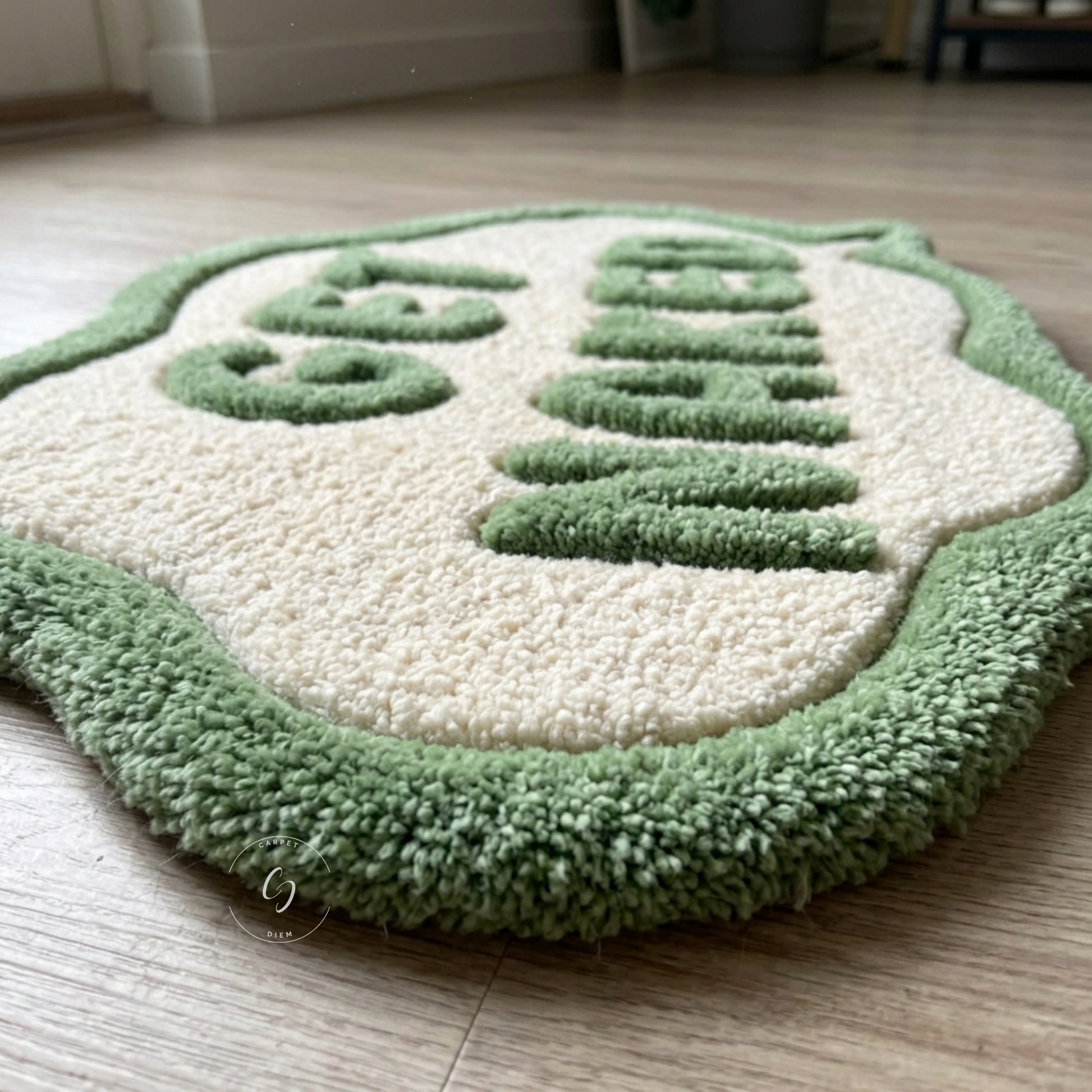 A plush, high-pile area hand tufted bathroom entrance rug shaped like a cartoon character's face, featuring a cream-coloured centre and green get naked raised lettering and border, placed on a light wood floor.