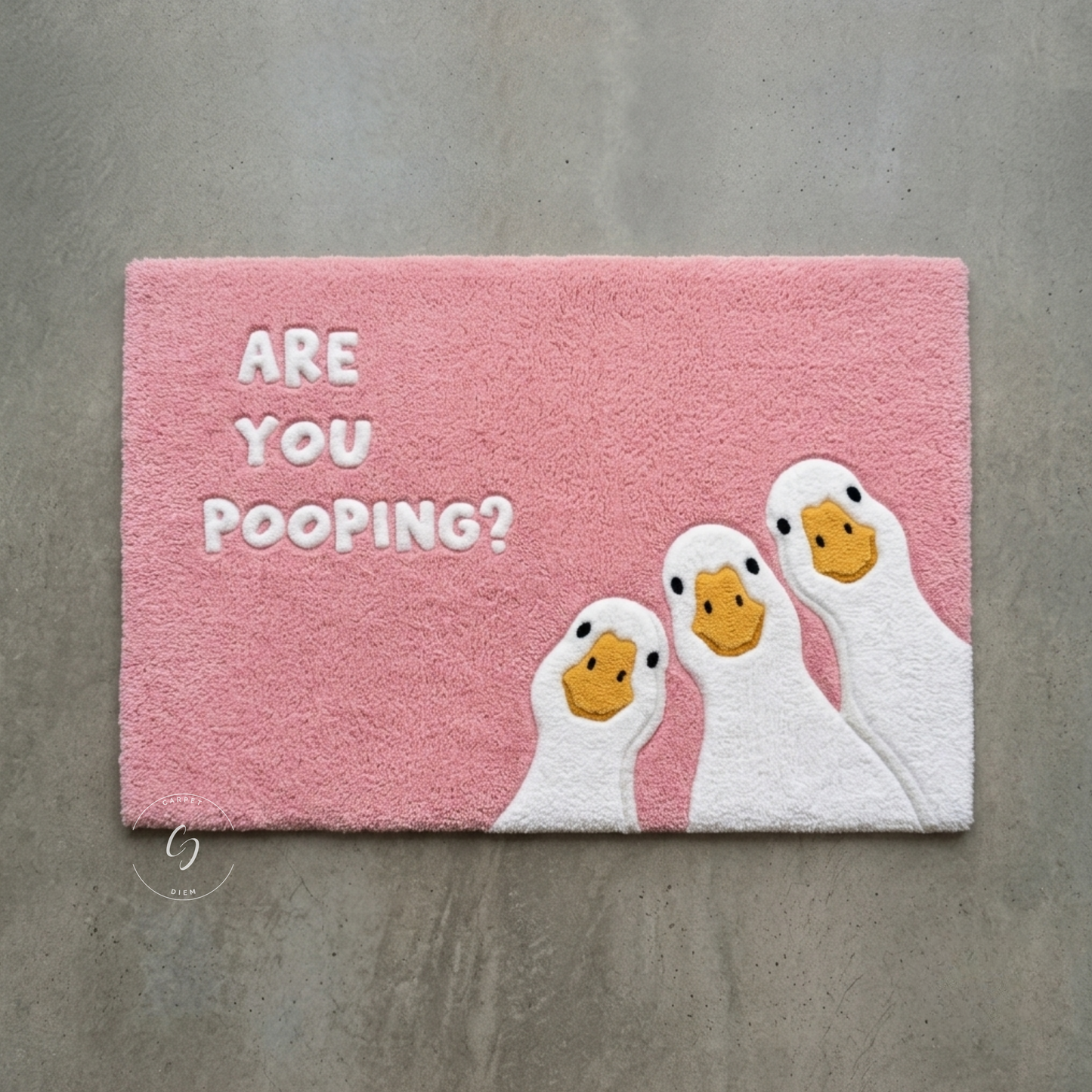 A rectangular pink hand tufted bathroom entrance rug with the text 'ARE YOU POOPING?' in white letters and three cartoon white ducks with yellow beaks.