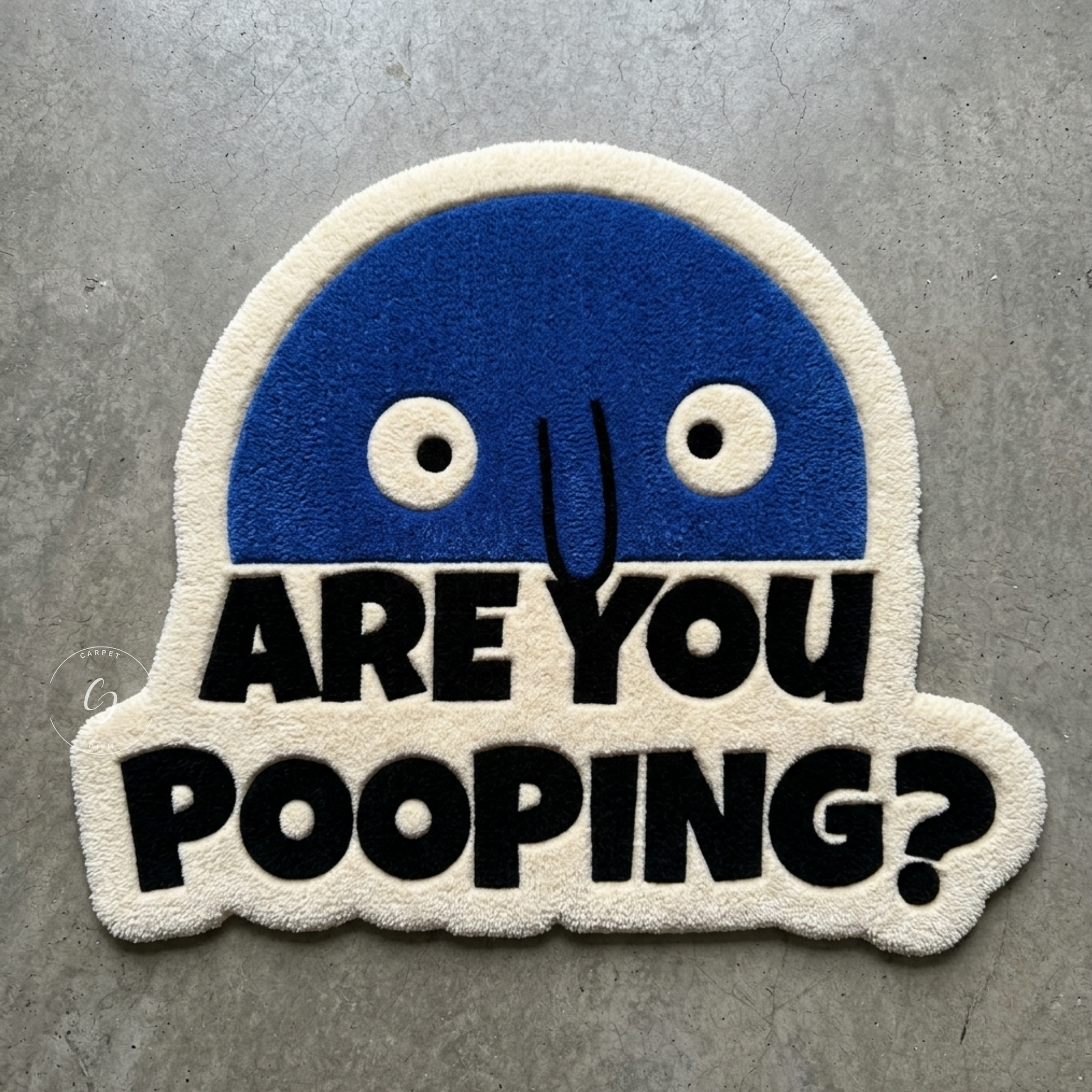 A novelty hand tufted bathroom entrance rug featuring a blue cartoon face above the bold black text 'ARE YOU POOPING?' on a cream fuzzy background, placed on a gray concrete floor.