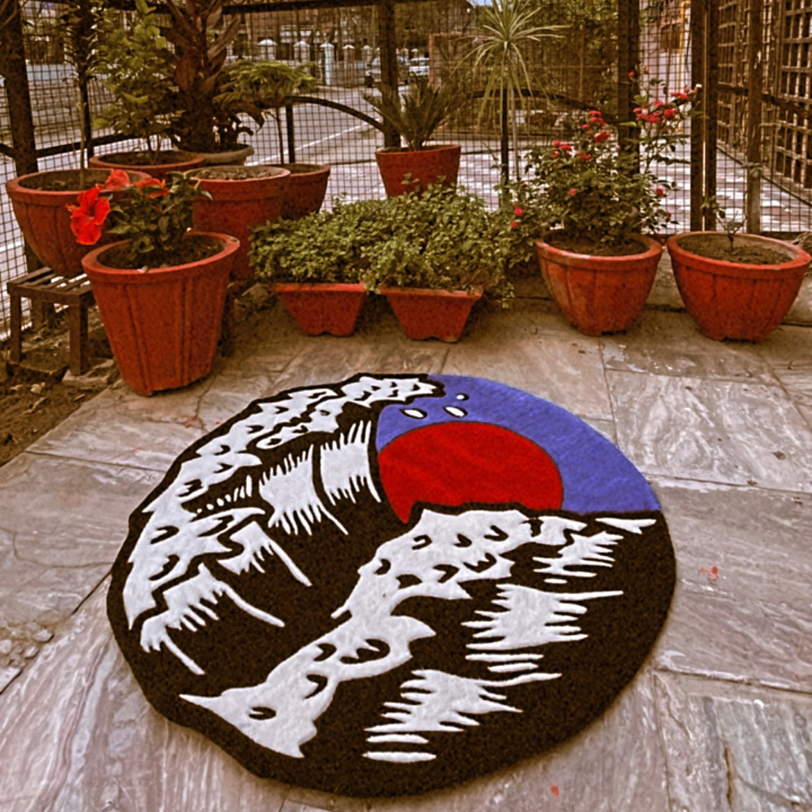 Artistic accent round tufted rug displaying the famous Great Wave woodblock print pattern 