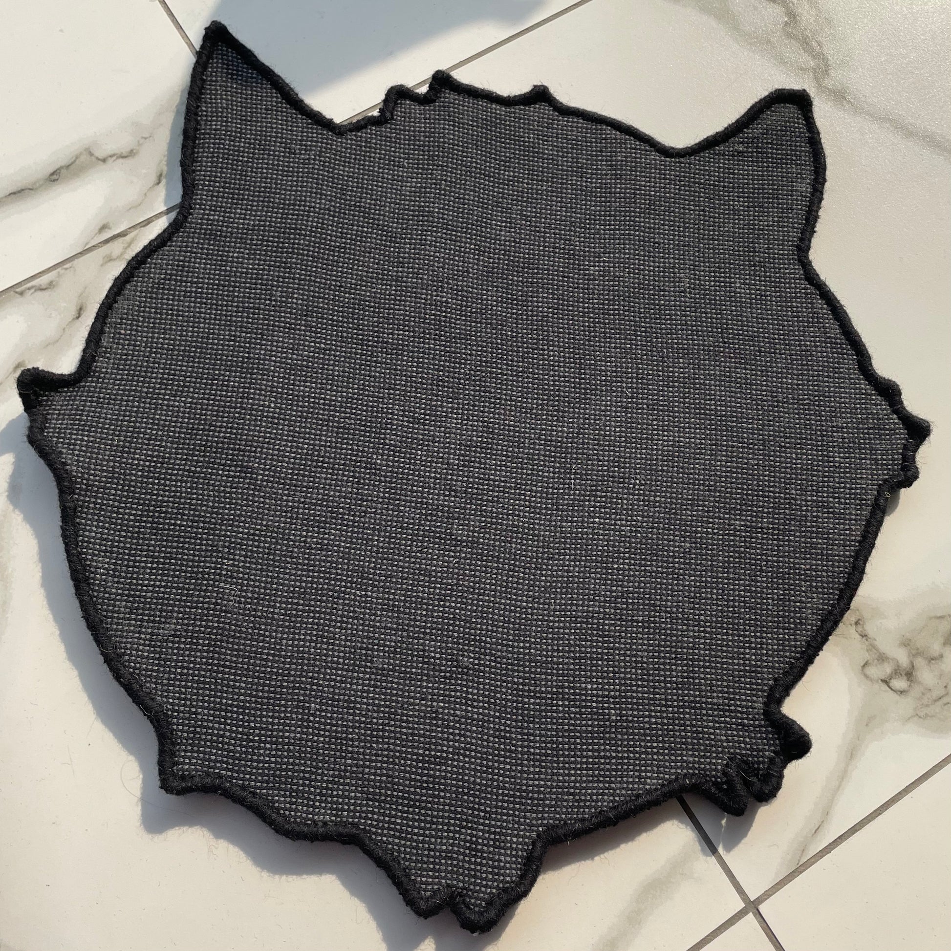 Black cat rug with big white eyes back side