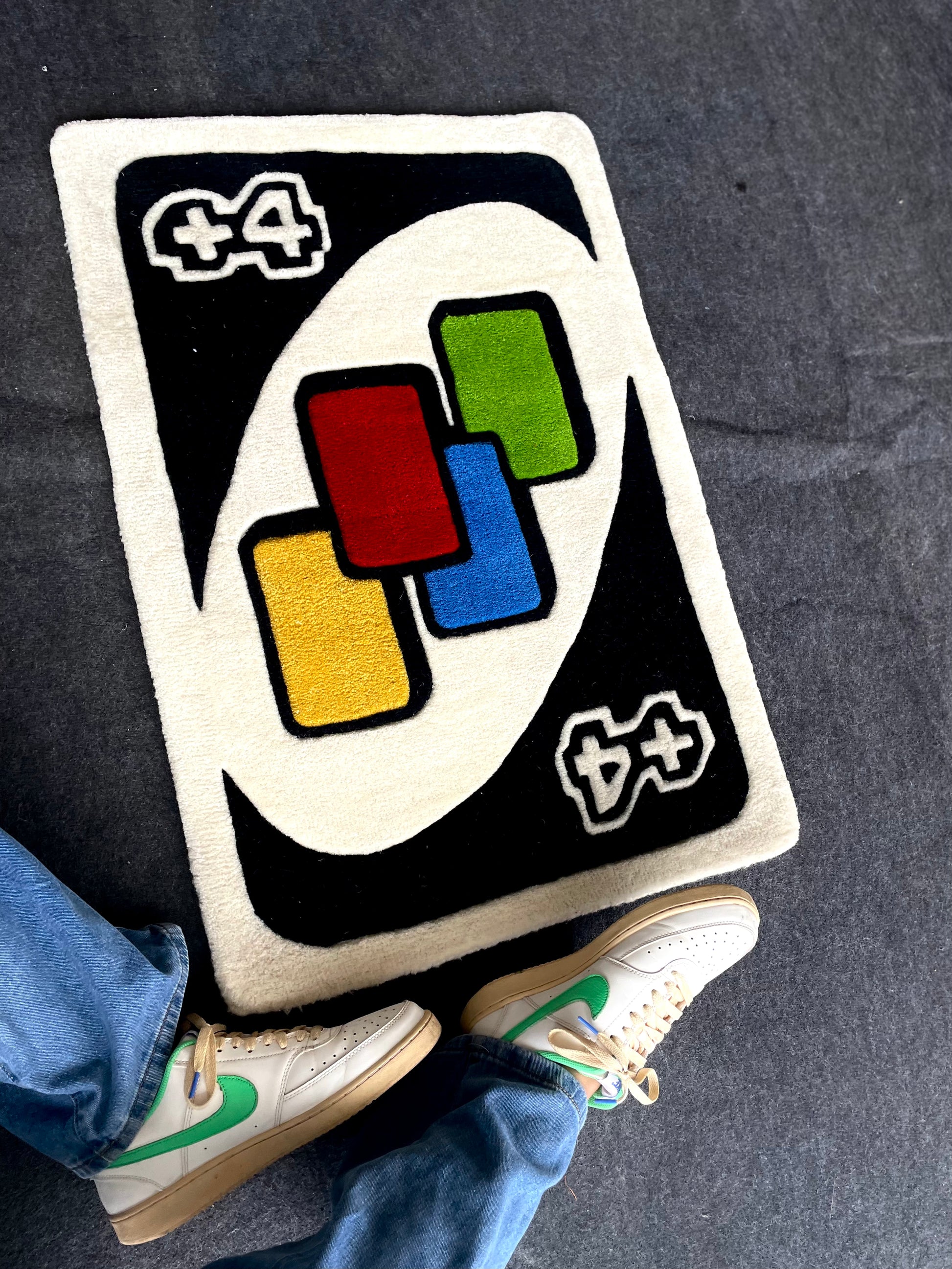  UNO Draw Four (+4) card tufted rug  with bold red, blue, yellow, and green quadrants.