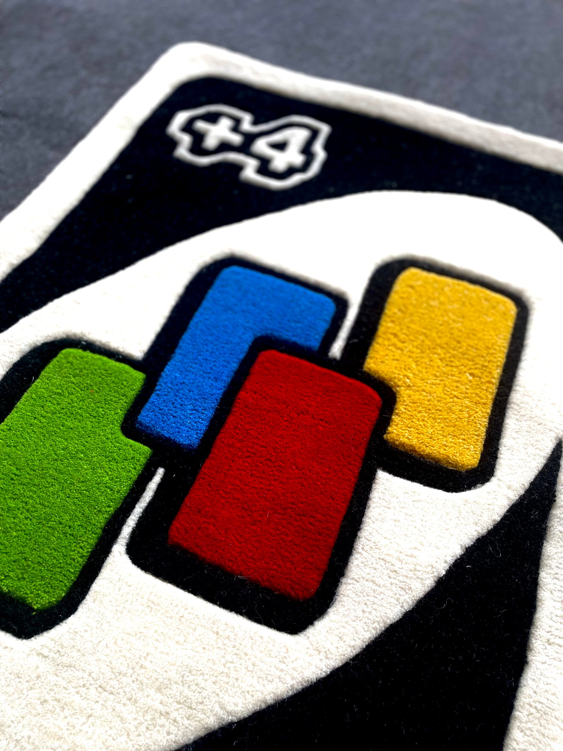 Closeup of uno draw four card hand tufted rug showing vibrant colours and premium wool used for making this rug